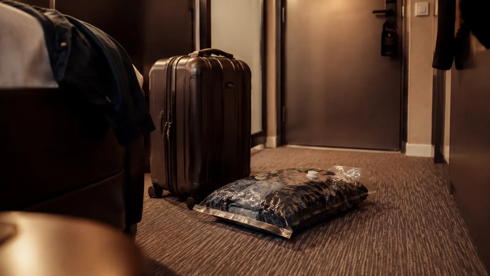 Dirty laundry sealed in a vacuum bag beside a hotel door ready for departure