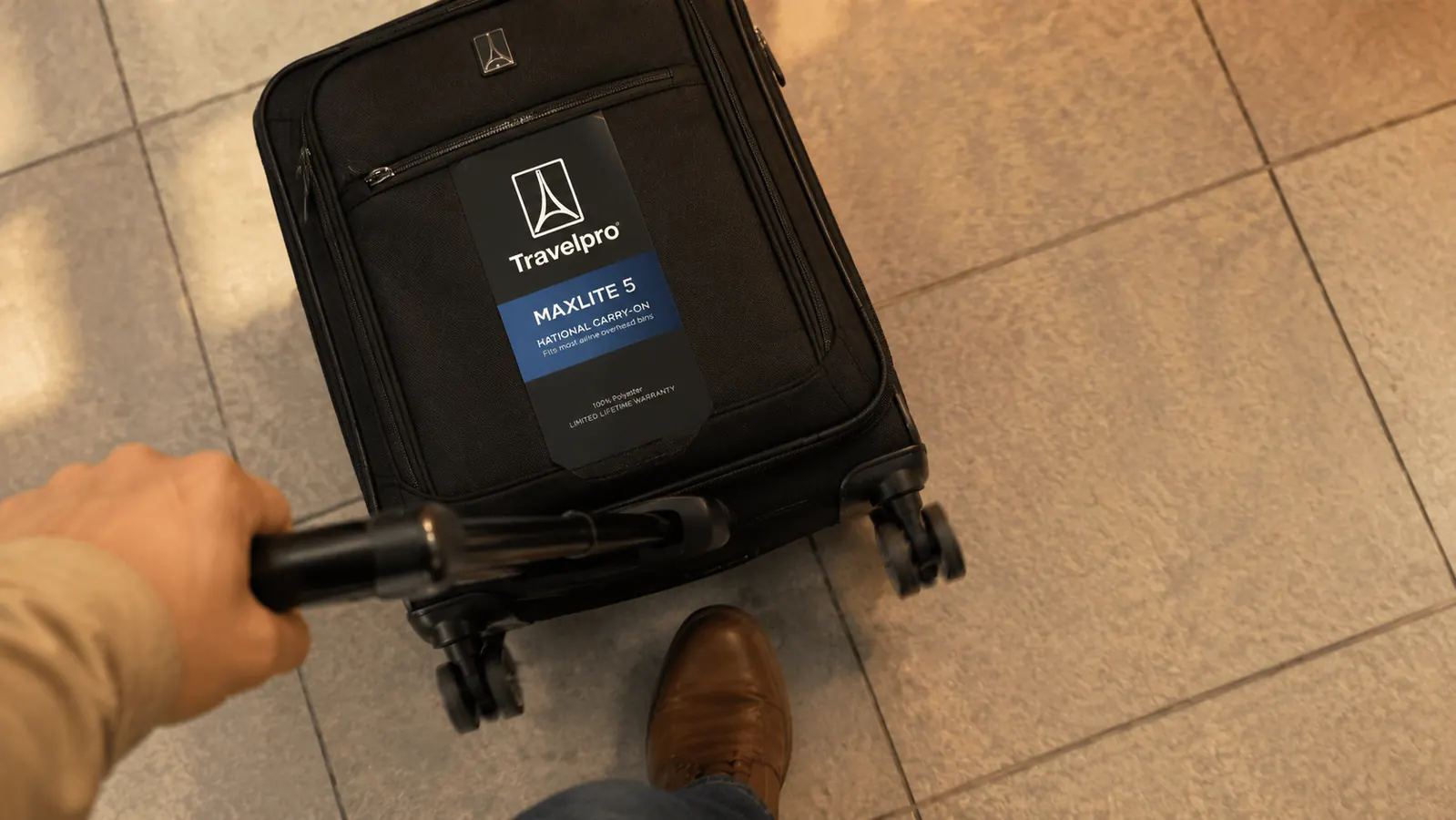 Close-up of the Travelpro Maxlite 5 spinner wheels on a tile floor showing minimal wear after heavy use